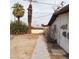 This backyard features landscaping, tall palm trees, and a sidewalk at 1413 Bryn Mawr Ave, Las Vegas, NV 89102