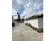Side exterior view with concrete driveway, detached garage, and mature palm trees at 1413 Bryn Mawr Ave, Las Vegas, NV 89102