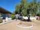 Landscaped front yard featuring a large tree, decorative features, and lush plants at 1413 Bryn Mawr Ave, Las Vegas, NV 89102
