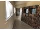 Hallway featuring stone accent wall, tiled floor, and view into another room at 1427 San Felipe Dr, Boulder City, NV 89005