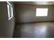 A spacious living room with tile floors and natural light from two large windows at 1427 San Felipe Dr, Boulder City, NV 89005
