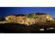 A single story stucco house with palm trees and circular driveway and some exterior holiday lighting at 1440 Lost Creek Dr, Pahrump, NV 89048