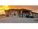 Single story stucco house with a circular driveway, stone accents and a dark car parked outside at 1440 Lost Creek Dr, Pahrump, NV 89048