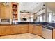 Kitchen with wooden cabinets, black countertops, stainless steel appliances, and tile floors at 1440 Lost Creek Dr, Pahrump, NV 89048