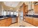 Traditional eat-in kitchen with tile floor, natural wood cabinets, stainless dishwasher and black countertops at 1440 Lost Creek Dr, Pahrump, NV 89048