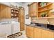 Well-organized laundry room with cabinets, shelving, and black countertops at 1440 Lost Creek Dr, Pahrump, NV 89048