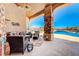 Outdoor living space features a large brick pillar, wood ceiling and stunning views of the pool and mountains at 1440 Lost Creek Dr, Pahrump, NV 89048