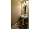 Small powder room features a pedestal sink, mirror, modern lighting, and neutral wall color at 16 Via Visione # 102, Henderson, NV 89011