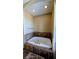 Corner bathtub with tile surround and ceiling lights at 16 Via Visione # 102, Henderson, NV 89011