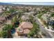 Lushly landscaped neighborhood featuring a home with a red tile roof and a backyard pool at 1859 Woodhaven Dr, Henderson, NV 89074