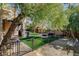 Lush backyard showcases outdoor cooking, a cozy fire pit with seating, and mature trees at 1859 Woodhaven Dr, Henderson, NV 89074