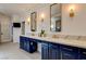 Bathroom featuring dual sinks with stylish blue cabinetry and gold fixtures at 1859 Woodhaven Dr, Henderson, NV 89074