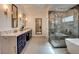 Bathroom featuring an elegant tub, marble shower, double vanity, and modern lighting at 1859 Woodhaven Dr, Henderson, NV 89074