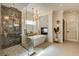 Modern bathroom featuring a freestanding tub, fireplace, marble shower and stylish chandelier at 1859 Woodhaven Dr, Henderson, NV 89074