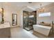 Bathroom featuring an elegant tub, marble shower, double vanity, and modern lighting at 1859 Woodhaven Dr, Henderson, NV 89074