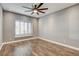 This bedroom features hardwood floors, a ceiling fan, and a set of white plantation shutters at 1859 Woodhaven Dr, Henderson, NV 89074