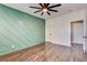 Modern bedroom featuring accent wall, wood floors, ceiling fan and ample natural light at 1859 Woodhaven Dr, Henderson, NV 89074