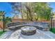 Cozy stone fire pit with built-in seating, perfect for outdoor gatherings at 1859 Woodhaven Dr, Henderson, NV 89074