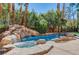 Lush pool area features a rock waterfall and mature landscaping at 1859 Woodhaven Dr, Henderson, NV 89074