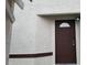 A close-up of a solid brown front door with a decorative window and matching trim at 1936 St Lawrence Dr, Las Vegas, NV 89108