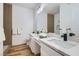 Bathroom featuring dual sinks, marble countertops, and elegant fixtures with wood-style flooring at 201 Kaelyn St # 4, Boulder City, NV 89005
