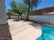 View of the backyard with a cement patio, partial pool and tall wall for privacy at 206 Valerian St, Henderson, NV 89015