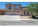 Two-story home featuring a three-car garage and a neutral stucco exterior with a tiled roof at 206 Valerian St, Henderson, NV 89015