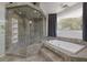 Primary bathroom featuring a glass enclosed shower and a jacuzzi tub with natural light at 2221 S Tioga Way, Las Vegas, NV 89117