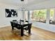 Bright dining room featuring a modern chandelier, a black dining set, and a large window with a tropical outdoor view at 2221 S Tioga Way, Las Vegas, NV 89117