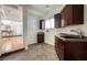 A quaint kitchenette area with dark wood cabinets, a sink, and tile flooring at 2221 S Tioga Way, Las Vegas, NV 89117