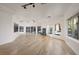 Bright living room with hardwood floors, modern lighting and fireplace, and views of the lush landscaped outdoors at 2221 S Tioga Way, Las Vegas, NV 89117