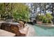 An outdoor kitchen featuring a built-in grill and stone countertops by a uniquely landscaped pool at 2221 S Tioga Way, Las Vegas, NV 89117