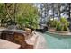 An outdoor kitchen featuring a built-in grill and stone countertops by a uniquely landscaped pool at 2221 S Tioga Way, Las Vegas, NV 89117