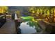 A unique rock pool features artificial rock formations, a bridge, and lush landscaping at 2221 S Tioga Way, Las Vegas, NV 89117