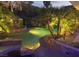 Nighttime view of the uniquely designed rock pool with waterfalls and lush landscaping at 2221 S Tioga Way, Las Vegas, NV 89117