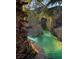 A unique rock pool features artificial rock formations, a waterfall, and lush landscaping at 2221 S Tioga Way, Las Vegas, NV 89117