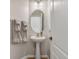 Bathroom featuring a pedestal sink and oval mirror with natural lighting at 2305 Dalton Ridge Ct, North Las Vegas, NV 89031