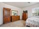 Bright bedroom features wood furniture, neutral walls, and a sunlit window at 2305 Dalton Ridge Ct, North Las Vegas, NV 89031