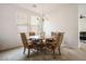 Well-lit dining room featuring a chandelier, wood table, and four decorative chairs at 2305 Dalton Ridge Ct, North Las Vegas, NV 89031