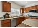 Well-lit kitchen featuring wood cabinets, granite countertops, stainless steel appliances, and a kitchen island at 2305 Dalton Ridge Ct, North Las Vegas, NV 89031