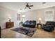Bright living room with tile floors, multiple windows, a ceiling fan and leather furniture at 2305 Dalton Ridge Ct, North Las Vegas, NV 89031