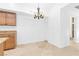 Eat-in kitchen features wood cabinetry, granite countertops, and chandelier lighting at 2615 W Gary Ave # 1041, Las Vegas, NV 89123
