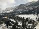 A winter view of snow covered trees on the mountains surrounding a house in the distance at 311 Crestview Dr, Las Vegas, NV 89124