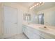 Bright bathroom featuring double sinks, tile flooring, a large mirror, vanity lighting, and white cabinets at 3235 S Tioga Way, Las Vegas, NV 89117