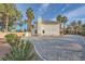Beautiful home with a spacious gravel driveway lined with palm trees, adding a touch of luxury at 3235 S Tioga Way, Las Vegas, NV 89117