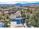 Inviting two-story home boasts a three-car garage and lush landscaping with mature palm trees at 3235 S Tioga Way, Las Vegas, NV 89117
