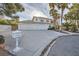 Charming two-story home with a three-car garage, long driveway, and manicured front yard landscaping at 3235 S Tioga Way, Las Vegas, NV 89117