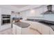 Kitchen featuring island, white cabinets, stainless steel appliances, and granite countertops at 3235 S Tioga Way, Las Vegas, NV 89117