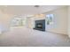 Spacious living room featuring neutral carpet, fireplace, and bright windows at 3235 S Tioga Way, Las Vegas, NV 89117