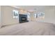 Bright living room featuring fireplace, neutral carpet, and backyard views at 3235 S Tioga Way, Las Vegas, NV 89117